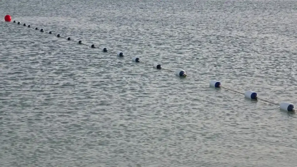 Swimming area demarcation line with floating buoys marking a designated swimming zone.